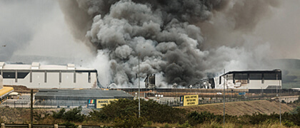 Industrial warehouse fire with thick black smoke